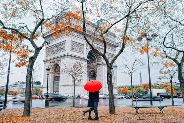 couple sous la pluie devant l'arc de triomphe à Paris en automne