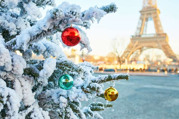 sapin de noël enneigé avec la tour eiffel en fond