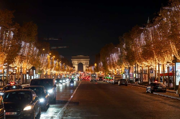 Champs Élysées illuminées avec l'Arc de Triomphe en fond