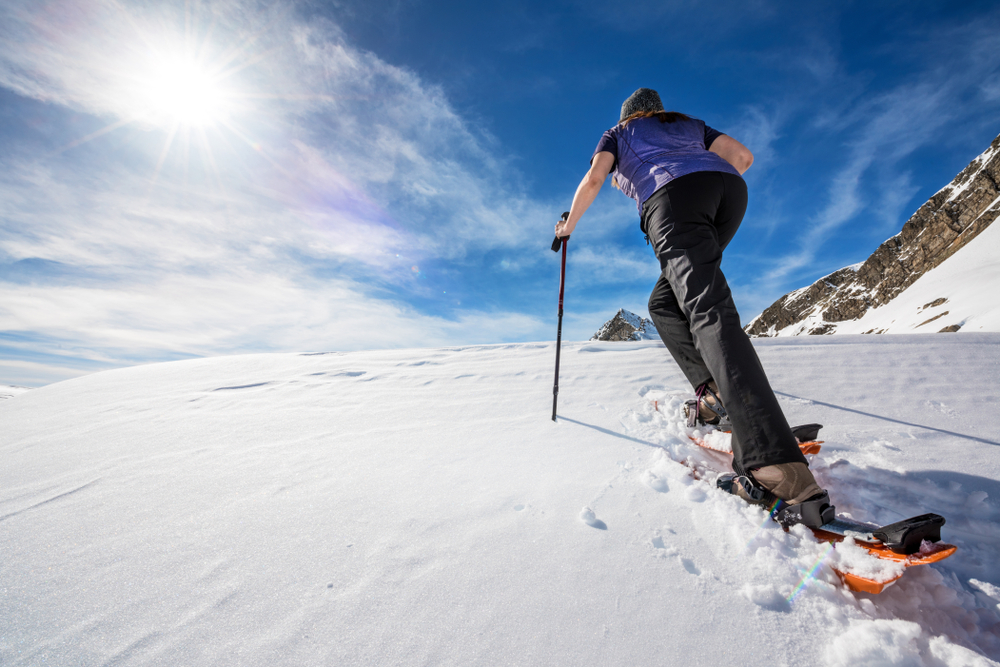 activité de raquettes en tshirt pour cette femme. Un avantage d'un séjour au ski en fin de saison hivernale