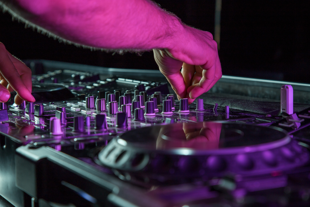 main sur les platines d'un DJ qui anime Tomorrowland Winter à l'Alpe d'Huez